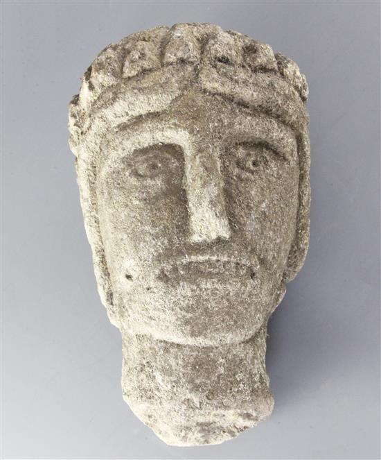 A 12th century Norman limestone head of a man or saint, height 11.75in.